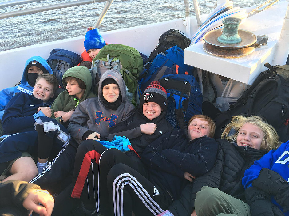 Scouts huddled together to avoid the cold wind on the short boat trip to Dog Island